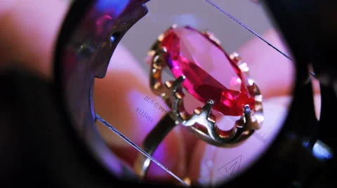Gold ring with red ruby through the measuring glass. Close up Stock Footage 45292509