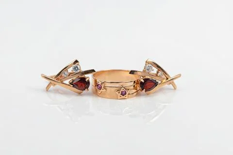 Gold ring with ruby inserts in the shape of stars and ruby earrings Stock Photos