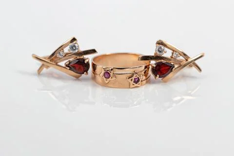 Gold ring with ruby inserts in the shape of stars and ruby earrings Stock Photos