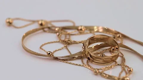 A gold ring with a sapphire, earrings and chains rotate on the stand around its  Stock Footage