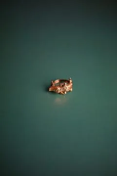 Gold ring in the shape of a crocodile on a background of emerald color Stock Photos