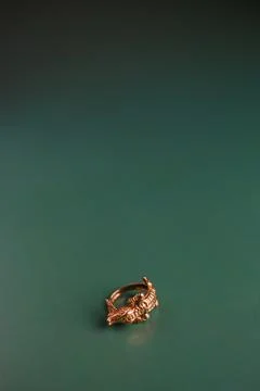 Gold ring in the shape of a crocodile on a background of emerald color Stock Photos