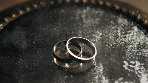 Gold rings with tiny splashes of water shimmering in the light. 库存影片 201368967