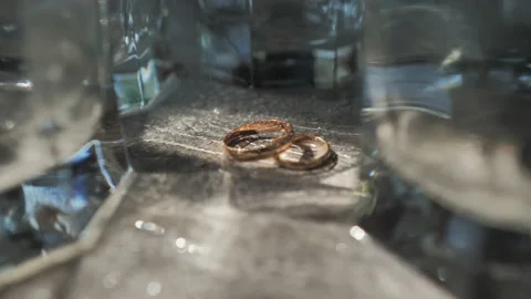 Gold rings with tiny splashes of water shimmering in the light. Stock Footage 213627838