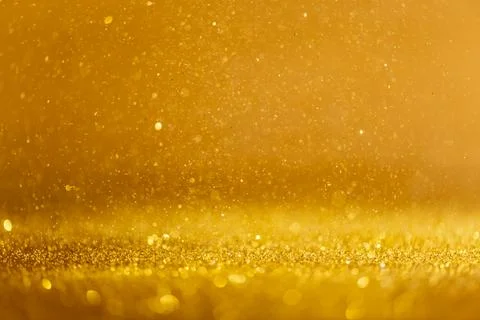 Gold sequins fall on a black background Stock Photos