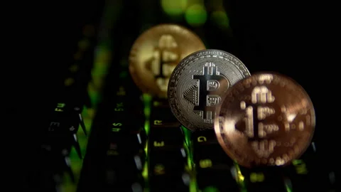 Gold, silver, bronze, bitcoin coins on the background of a flashing keyboard. Stock Footage 87546355