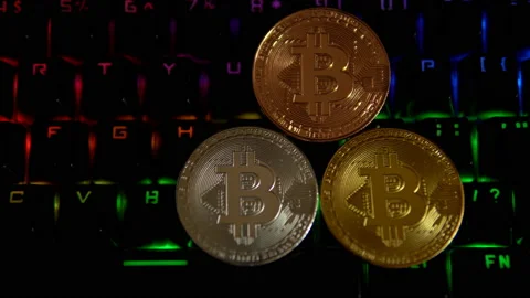 Gold, silver, bronze, bitcoin coins on the background of a flashing keyboard. Stock Footage 88273383