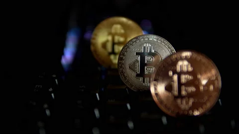 Gold, silver, bronze, bitcoin coins on the background of a flashing keyboard. Stock Footage 88274959