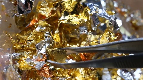 Gold, silver, copper leef extremely close-up, real time, tweezers mix shiny piec Stock Footage 149220053