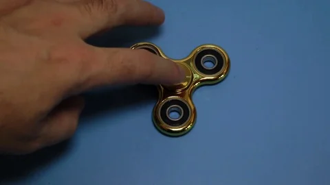 Gold spinner rotate on the blue background. Anti-stress. Stock Footage 82761536