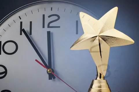 Gold star on a trophy in front of a clock Stock Photos