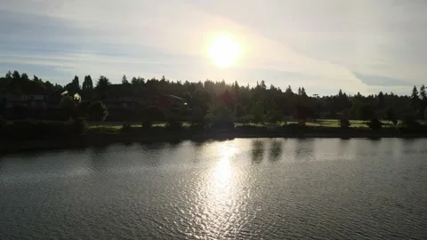 Gold Sun behind clouds over water ripples at Lions Field Park Bremerton Kitsap Stock Footage 154985070