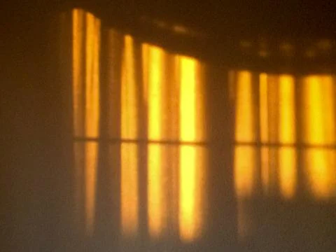 Gold sunlight streams through curtains for golden design background Stock Photos