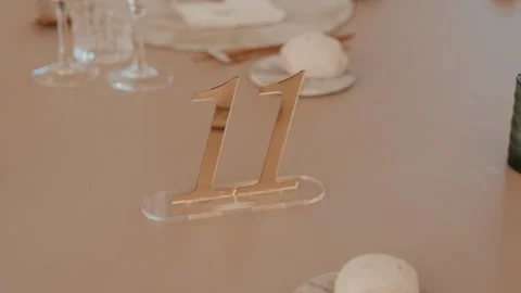 Gold Table Number Eleven on Set Banquet Table with Glasses and Bread Stock Footage 343697907