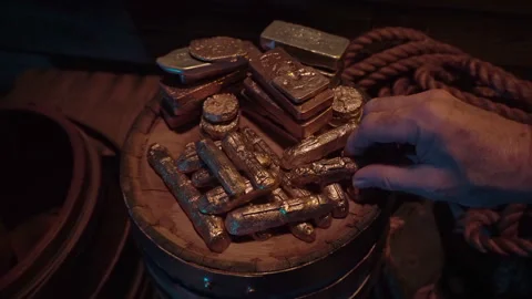 Gold treasure piled up on a barrel top. Hand sneakily grabs an ingot. Stock Footage 344059562