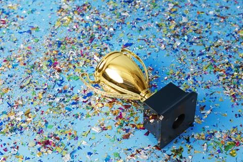 Gold trophy on a confetti background Stock Photos