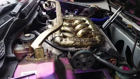 A gold vehicle engine being warmed up Stock Footage 290100609