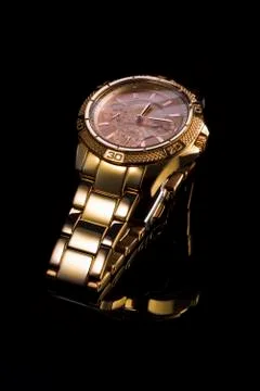 Gold watch on a plastic background Stock Photos