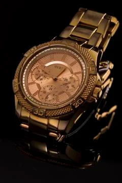 Gold watch on a plastic background Stock Photos
