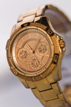 Gold watch on a plastic background Stock Photos