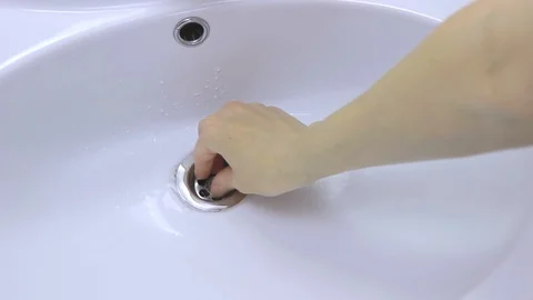 Gold wedding ring accidentally falls into a white ceramic sink Stock Footage 128882091