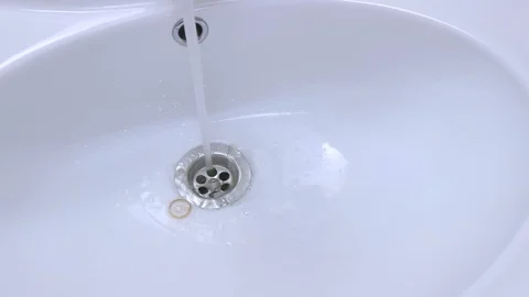 Gold wedding ring accidentally falls into a white ceramic sink Stock Footage 128882167