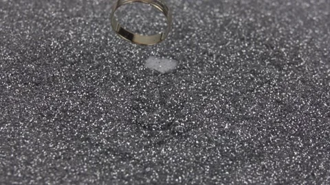 Gold wedding ring falls on silver sequins. Stock Footage 155544131