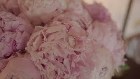 Gold Wedding Ring Resting on Pink Peony Petals in Bridal Bouquet Stock Footage 343751349