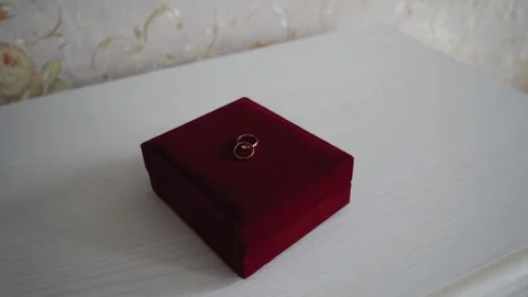 Gold wedding rings lie on a red velvet box Stock Footage 306157535