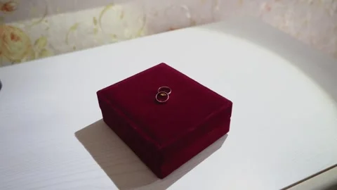 Gold wedding rings lie on a red velvet box Stock Footage 306157655