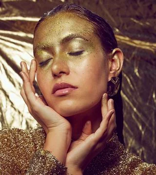 Gold, woman model and beauty sparkle of a female with makeup and cosmetic Stock Photos