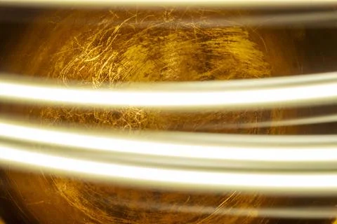 Golden abstract texture with bright light streaks on dark background Stock Photos