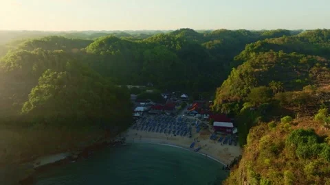 Golden aerial view captures a secluded Ngerenean lagoon enclosed by rugged .. Stock Footage 341545404