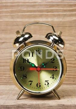 Golden alarm clock on wooden table Stock Photos