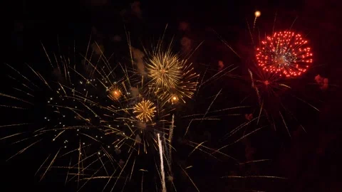 Golden and red fireworks exploding in the night sky Video stock 332858597