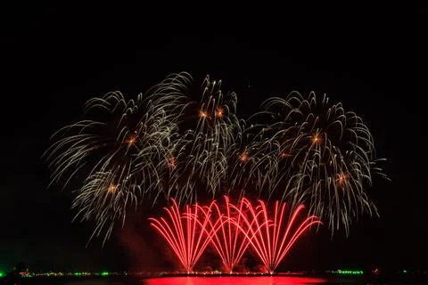 Golden And Red Fireworks Exploding Over Calm Sea Water At Night During Holi.. Стоковые фото