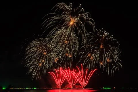 Golden And Red Fireworks Exploding Over Water At Night Long Exposure Shot Fotos de archivo