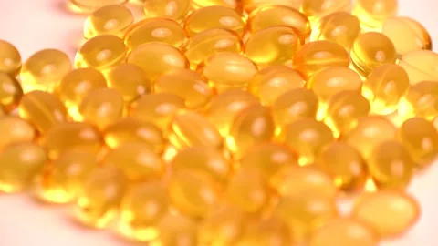 Golden background capsules Close up supplement oil filled capsules vitamin A Stock Footage 152472152