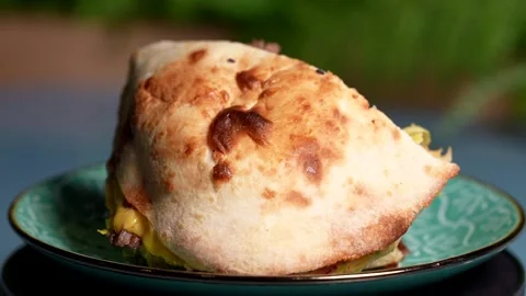 Golden baked flatbread stuffed with melted cheese and beef  Stock Footage 313880542