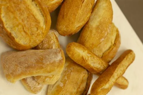 Golden bakery bread assortment with rolls and ciabatta on clean white surface Stockfoto's