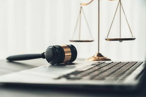 Golden balanced scale and gavel on desk with laptop in law office. equility Stock Photos