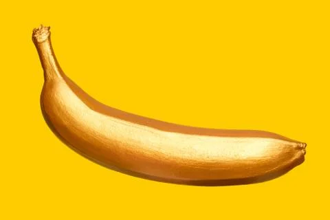 Golden banana on a yellow background. Creative concept with fruit. Stock Photos