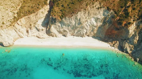Golden beach embraced by rugged cliffs and lush hillside vegetation in summer Stock Footage 320090333