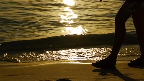 Golden Beach Scene: Sunset Waves and People Silhouettes Stock Footage 276818429