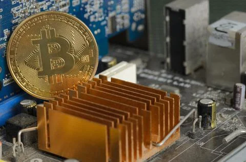 Golden bitcoin on the background of an electronic computer board. 스톡 사진