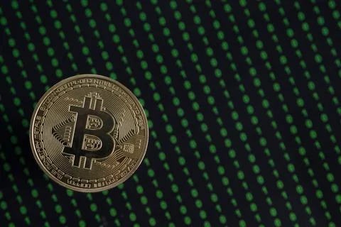 Golden Bitcoin, binary code on a blurry black background. Stockfoto's