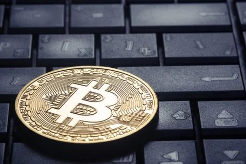 Golden bitcoin on the computer keyboard Stock Photos