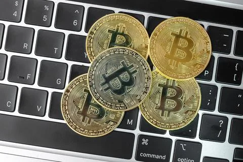 Golden Bitcoin cryptocurrency coin stack on laptop keyboard, Crypto is Digita Stock Photos
