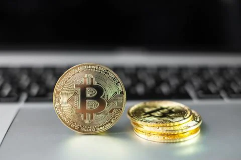 Golden Bitcoin cryptocurrency coin stack on laptop keyboard, Crypto is Digita Stock Photos