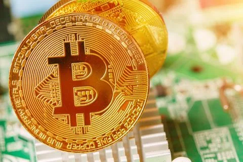 Golden Bitcoin Cryptocurrency on computer circuit board. Macro shot Stock Photos